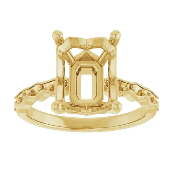 Gold engagement ring setting with French-set accent stones and emerald-cut center stone head.
