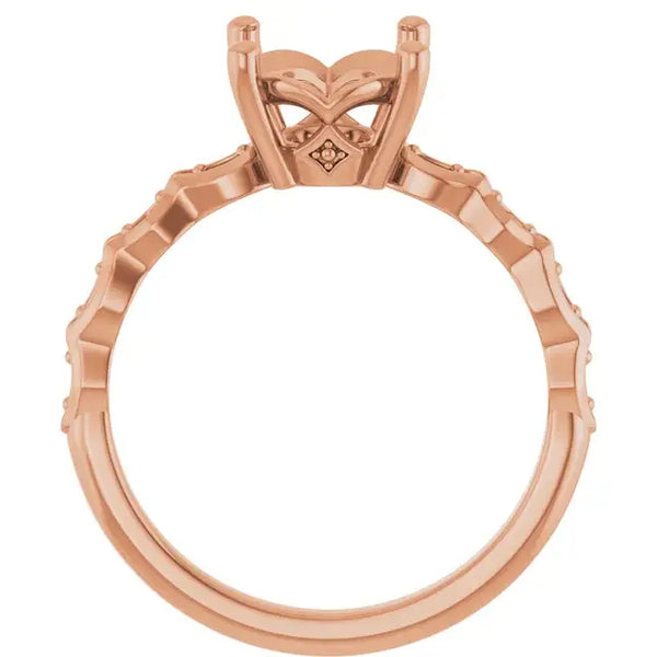 Rose gold engagement ring setting with oval stone head, decorative prongs, and textured band.