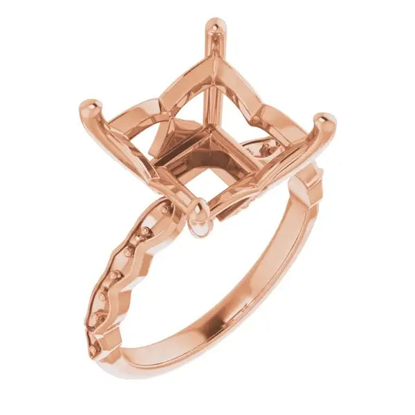 Rose gold engagement ring setting with cushion-shaped stone holder and decorative band detailing.