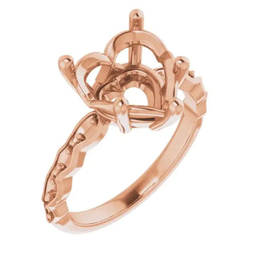 Rose gold engagement ring setting with ornate crown-style head and decorative band for heart-shaped stone.