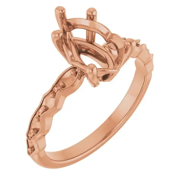 Rose gold engagement ring setting with pear-shaped stone holder and French-set diamond accents on band.