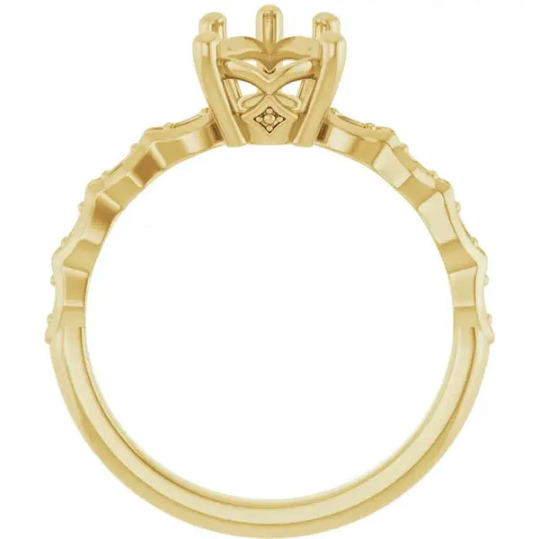 Gold engagement ring setting with pear-shaped stone holder featuring French-set accents along the band.