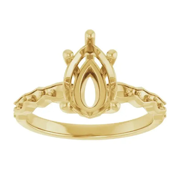 Gold engagement ring setting with pear-shaped stone holder and decorative shoulders, viewed from front.