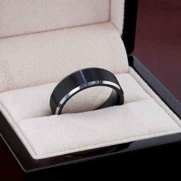 Lifestyle close-up of black brushed-center tungsten ring with polished beveled edges