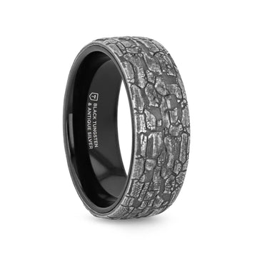 Angled side view of an 8mm black tungsten wedding band with textured grey stonework pattern and polished black interior