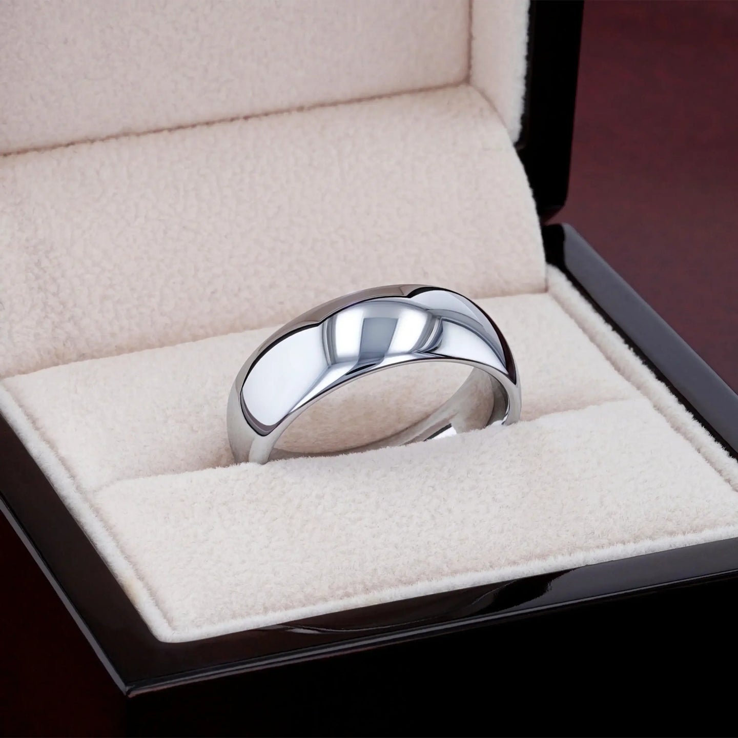 DOMINUS domed tungsten carbide ring photographed on textured stone surface, angled view