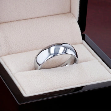 DOMINUS domed tungsten carbide ring photographed on textured stone surface, angled view