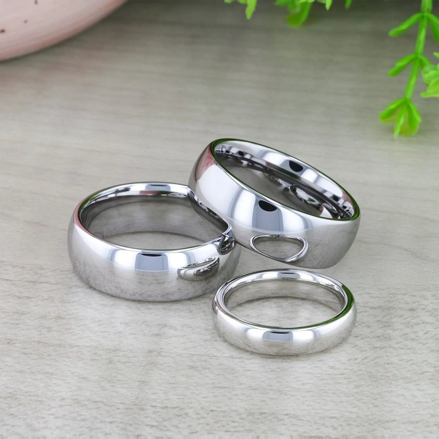 DOMINUS domed tungsten carbide ring resting on dark textured background, close-up