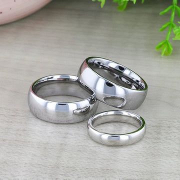 DOMINUS domed tungsten carbide ring resting on dark textured background, close-up