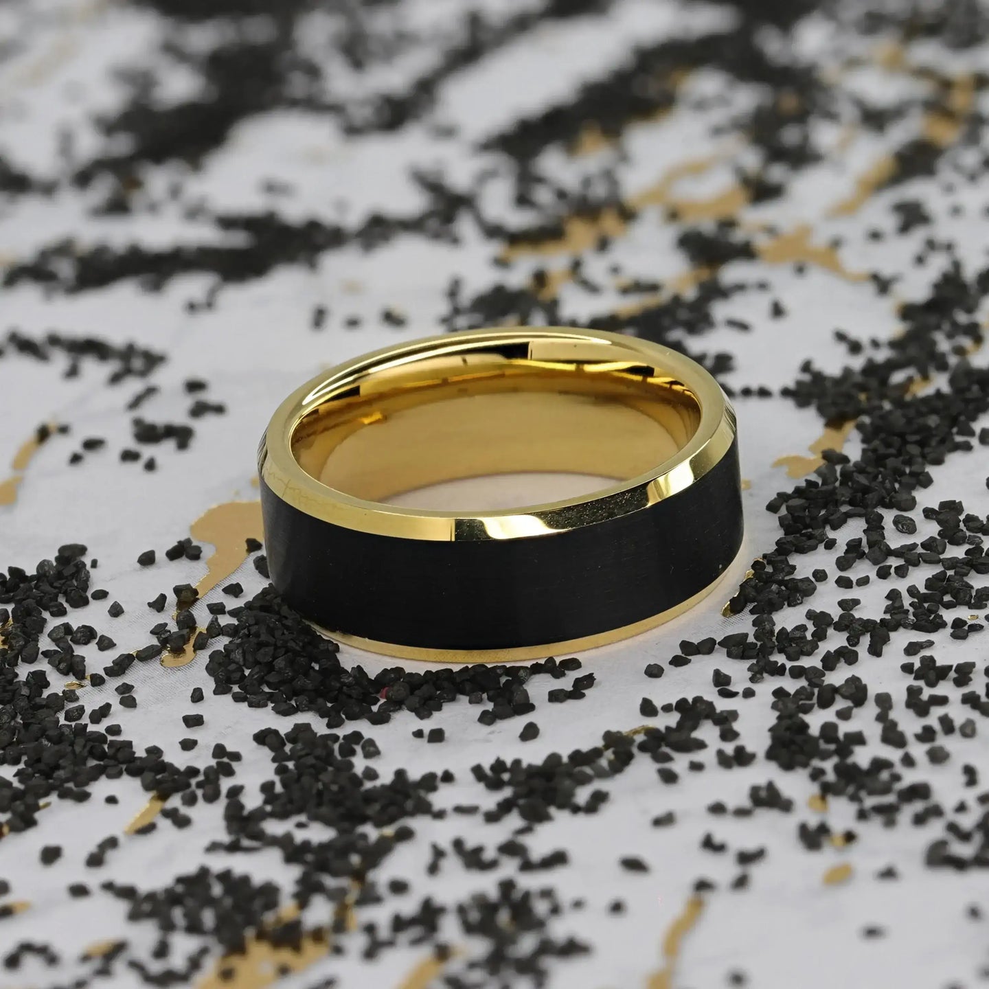 Ring displayed in a cream jewelry box, showing interior gold finish and black brushed exterior center