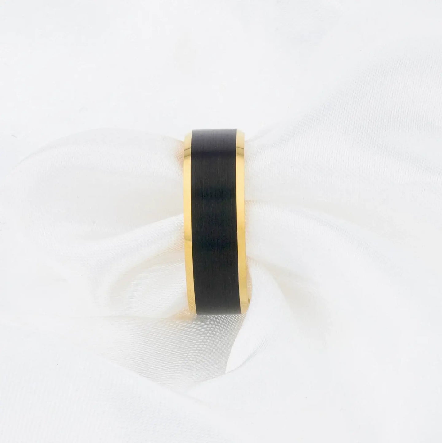 Three rings of the same style in different widths, showcasing brushed black centers and gold edges