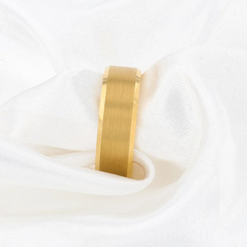 Gold-plated tungsten ring displayed on white fabric, showing brushed center strip.