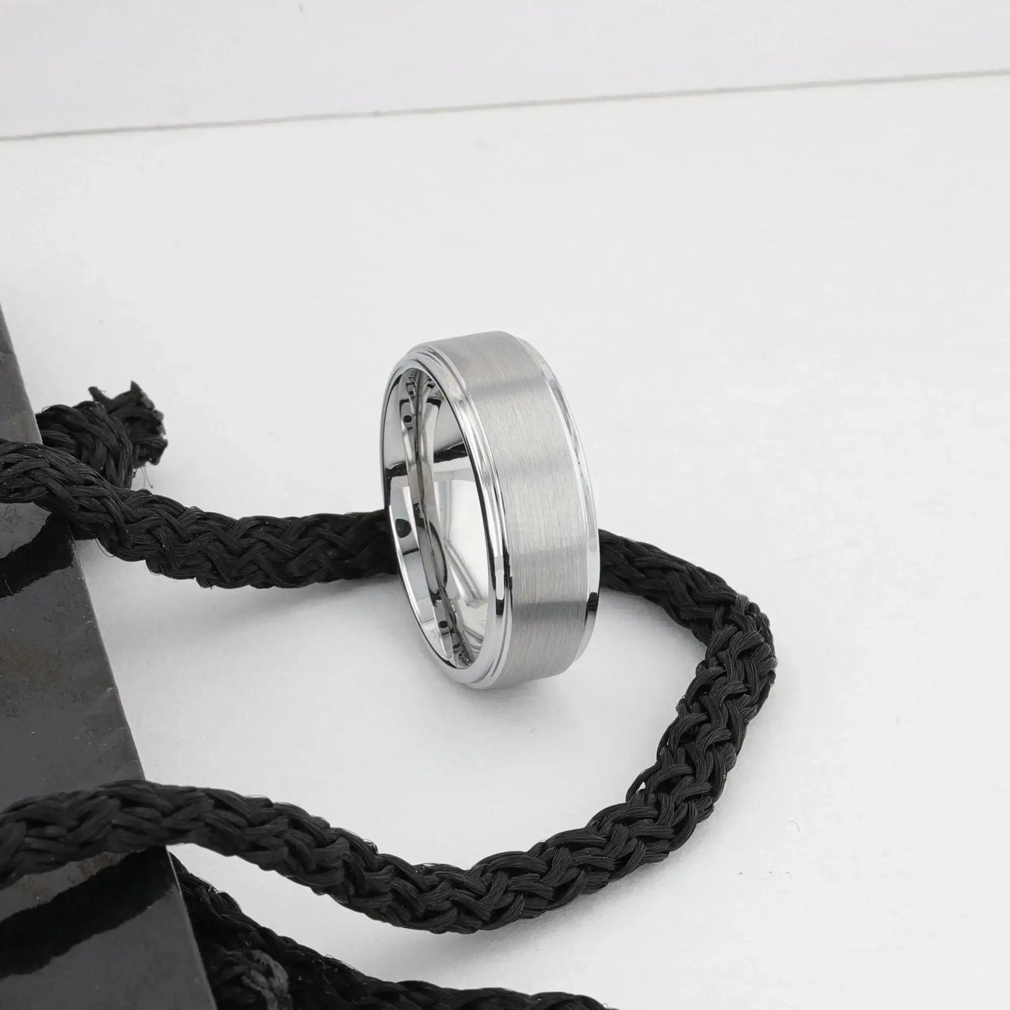 OPTIMUS tungsten ring standing against white decor, showing polished step edges