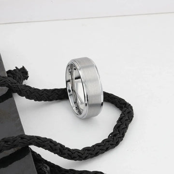 OPTIMUS tungsten ring standing against white decor, showing polished step edges