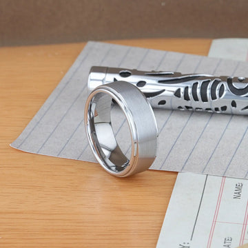 OPTIMUS tungsten ring on stone tile surface, highlighting raised brushed center