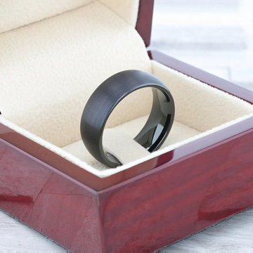 Lifestyle shot: black tungsten domed brushed ring resting in a jewelry box