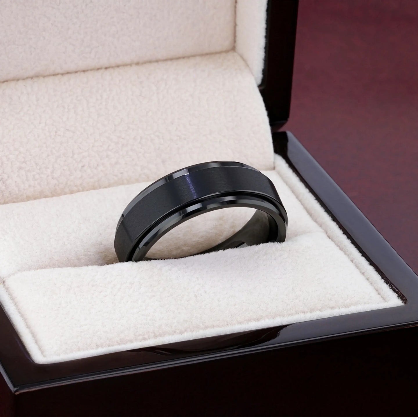 Close-up lifestyle shot of the REVOLVE black tungsten spinner ring on finger with polished domed edges