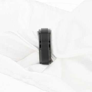 Lifestyle image of the REVOLVE black tungsten spinner ring worn on a hand, showing brushed spinner center