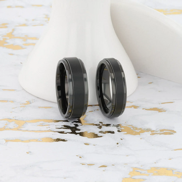 Macro detail image of the REVOLVE black tungsten spinner ring focusing on brushed spinner texture and polished edges
