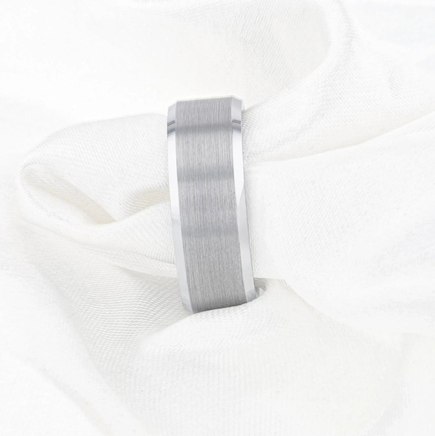 On-hand view of the Sheffield tungsten ring worn on a finger, showing its brushed center and polished beveled edge