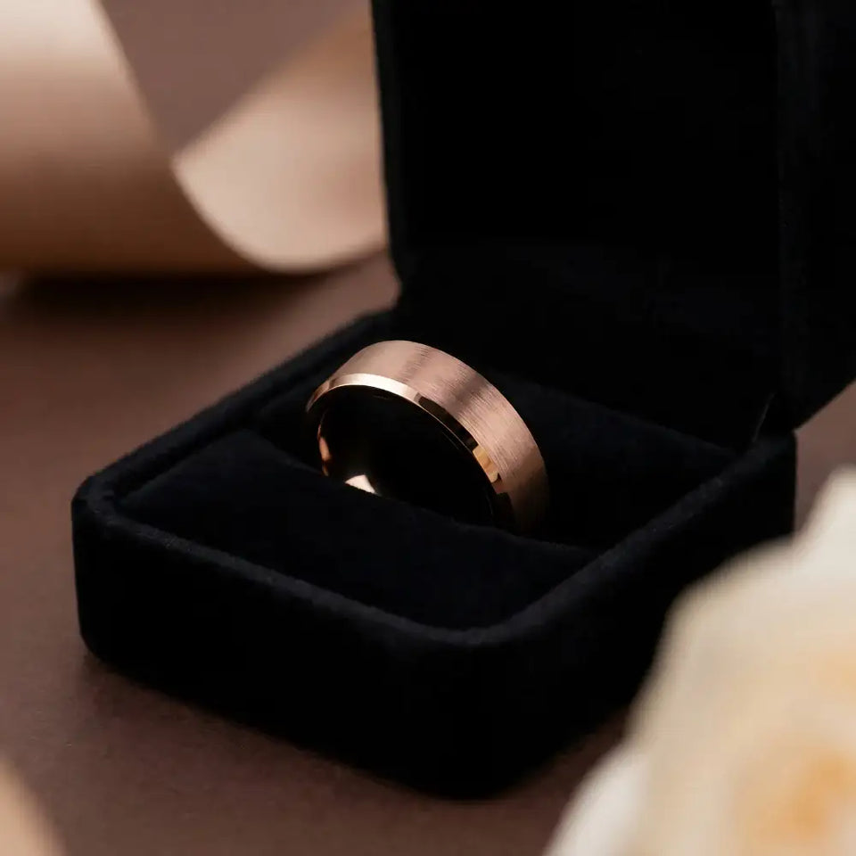 Flat tungsten carbide ring with brushed center and beveled edges displayed in black velvet ring box.