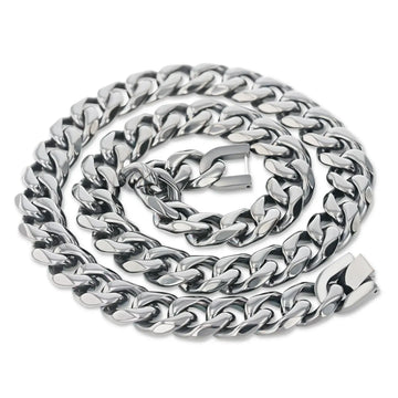 Close-up of a polished stainless steel Cuban link chain coiled with a box-style clasp visible
