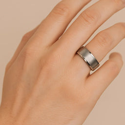 ANTARES white tungsten carbide wedding band shown on hand, 8mm with brushed center and polished beveled edges