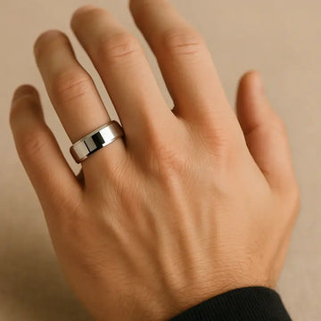 The polished 10mm beveled-edge tungsten carbide ring worn on a hand to show scale