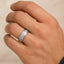 White tungsten carbide wedding band worn on a hand, showing satin center and polished step edges