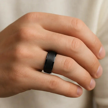 Black tungsten ring with satin center and polished step edges shown on a hand