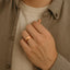 Lifestyle image showing a person wearing a polished rose gold–plated domed tungsten carbide ring on their hand.