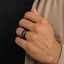 Lifestyle shot of the ABYSS black tungsten ring with meteorite inlay worn on a hand