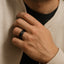Lifestyle shot of a man wearing a 9mm black tungsten carbide ring featuring a corrugated center and single black diamond