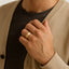 Man wearing a yellow gold-tone beveled-edge ring with satin center band on his left hand