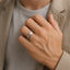 Lifestyle shot of a man wearing the brushed titanium flat wedding band on his ring finger