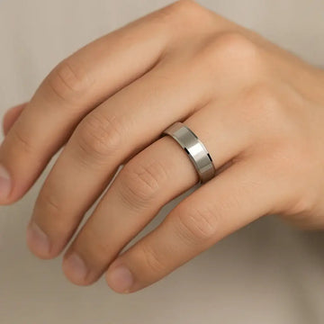Polished cobalt chrome beveled-edge ring worn on a hand, showing slim 4–6mm width and comfort-fit shine