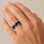 The black ceramic and tungsten band worn on a hand, demonstrating fit and profile