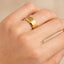 Hand wearing a gold-plated tungsten ring showing the brushed center and polished beveled edges.