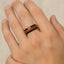 A hand wearing the 8mm black ceramic ring with Carpathian elm wood inlay