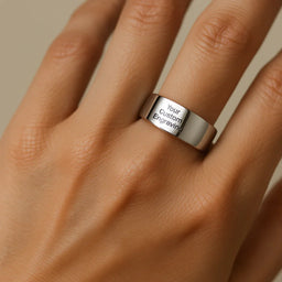 Polished tungsten carbide ring with custom engraving text shown worn on a hand