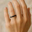 Women's black polished titanium domed ring, 2.5mm, shown on hand for scale
