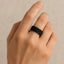 Lifestyle shot of the black spinel pavé sterling silver band worn on a hand