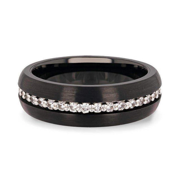 Flat lay of the domed black tungsten carbide ring highlighting the continuous white sapphire channel.
