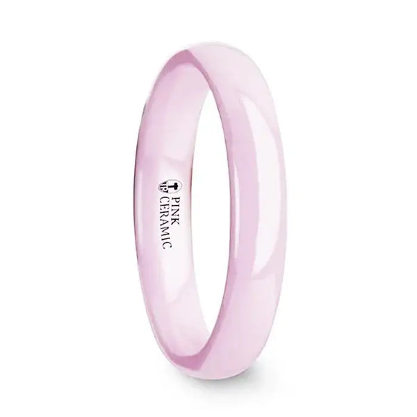 Side view of a polished pink ceramic domed wedding band, 4mm width, with interior marking that reads Pink Ceramic.