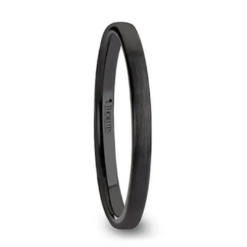 Black flat 2 mm ceramic wedding band with brushed finish shown at an angle on white background