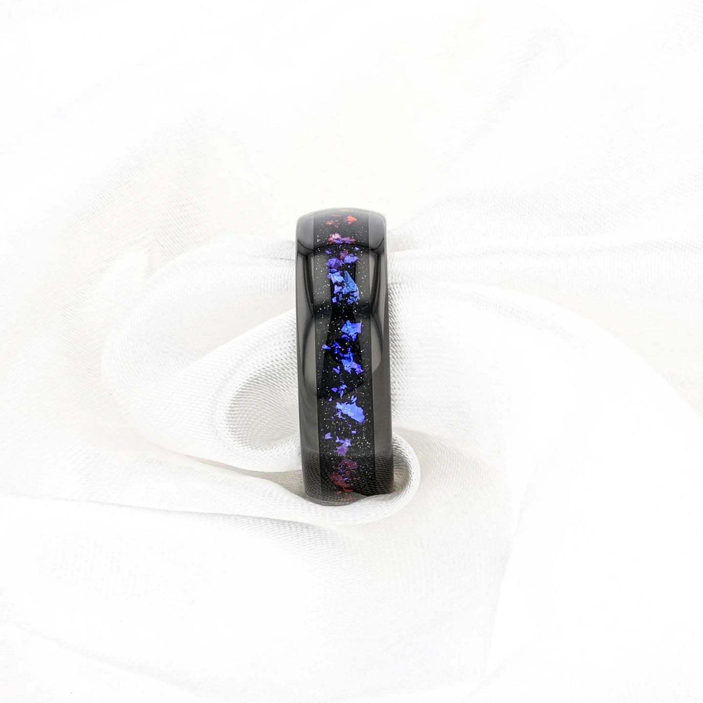 Lifestyle image of COSMIC black tungsten ring with crushed Alexandrite and goldstone inlay