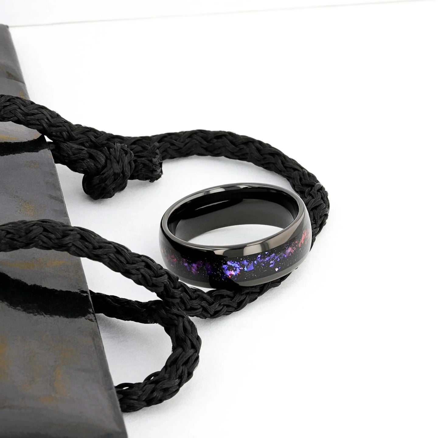 Close-up of COSMIC ring showing polished black tungsten and multicolor crushed inlay