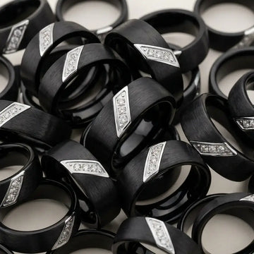 Black satin tungsten carbide wedding bands with diagonal silver diamond inlays displayed in rows.