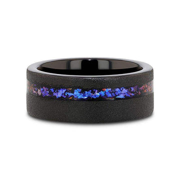 Flat lay of the 8mm sandblasted black tungsten ring highlighting the continuous crushed alexandrite and blue-purple goldstone inlay