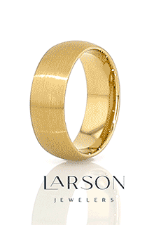 Lifestyle shot of the brushed gold-plated tungsten ring resting beside a black braided cord